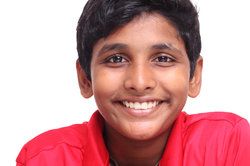 A boy in a red shirt smiling