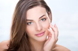 A young brunette woman with clear skin and a great smile